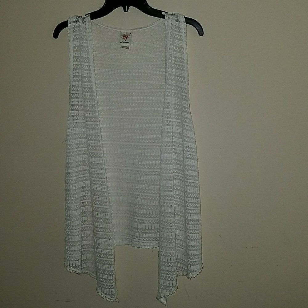 This is a white and laced sleeveless cardigan.